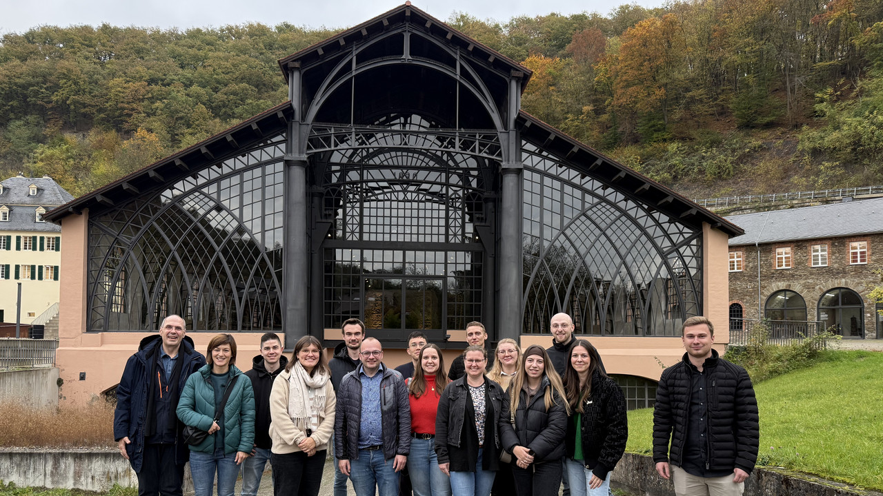 Dozent Joachim Weiler und Dozentin Verena Annen mit den Studierenden vor der Gießhalle. Das gusseiserne Tragwerk der Halle gilt als Prototyp einer industriellen Bauepoche mit einer atemberaubenden Architektur.