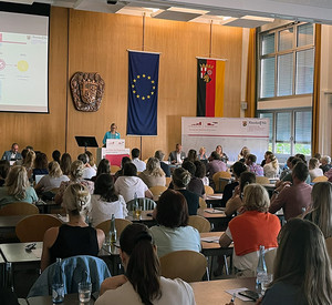 Vollbesetzte Aula der HöV/ZVS in Mayen. Direktorin Alice Schmidt steht vorne am Pult und begrüßt die Teilnehmenden.