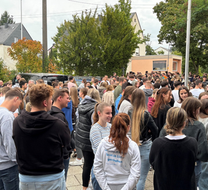 Menschengruppe nach der Evakuierungsübung am Sammelplatz vor dem Lehrsaalgebäude 1