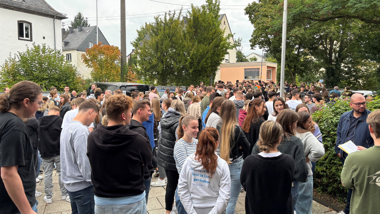 Menschengruppe nach der Evakuierungsübung am Sammelplatz vor dem Lehrsaalgebäude 1