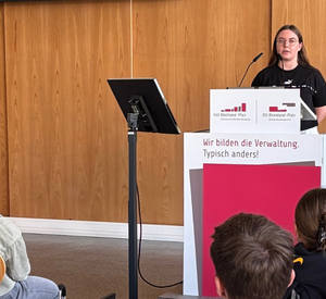Studierende am Rednerpult in der Aula 