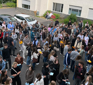 Viele Teilnehmende stehen mit Unterlagen im Innenhof der HöV RLP und ZVS RLP in Mayen. Sie warten in Gruppen vor einem Gebäude.