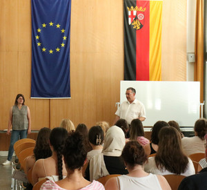 Christoph Fournier (Praxisbeauftragter der HöV) bei seinem Vortrag vor den Studierenden in der Aula der HöV und Frau Johann von der. a.i.m. rlp.