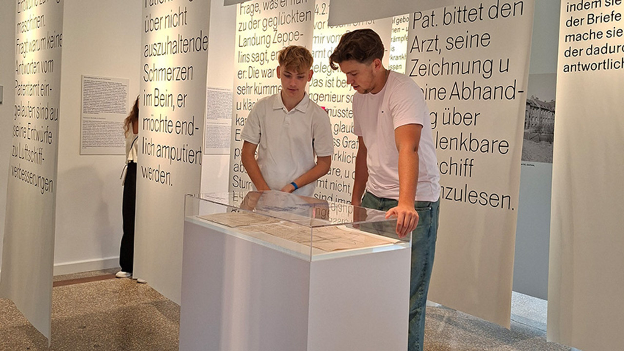 Zwei Studierende der HöV Rheinland-Pfalz betrachten historische Dokumente in einer Glasvitrine im Medizinhistorischen Museum der Charité.