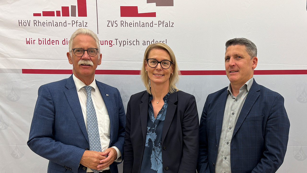 Gruppenfoto von Arne Rössel, Alice Schmidt und Fabian Göttlich vor der Pressewand.